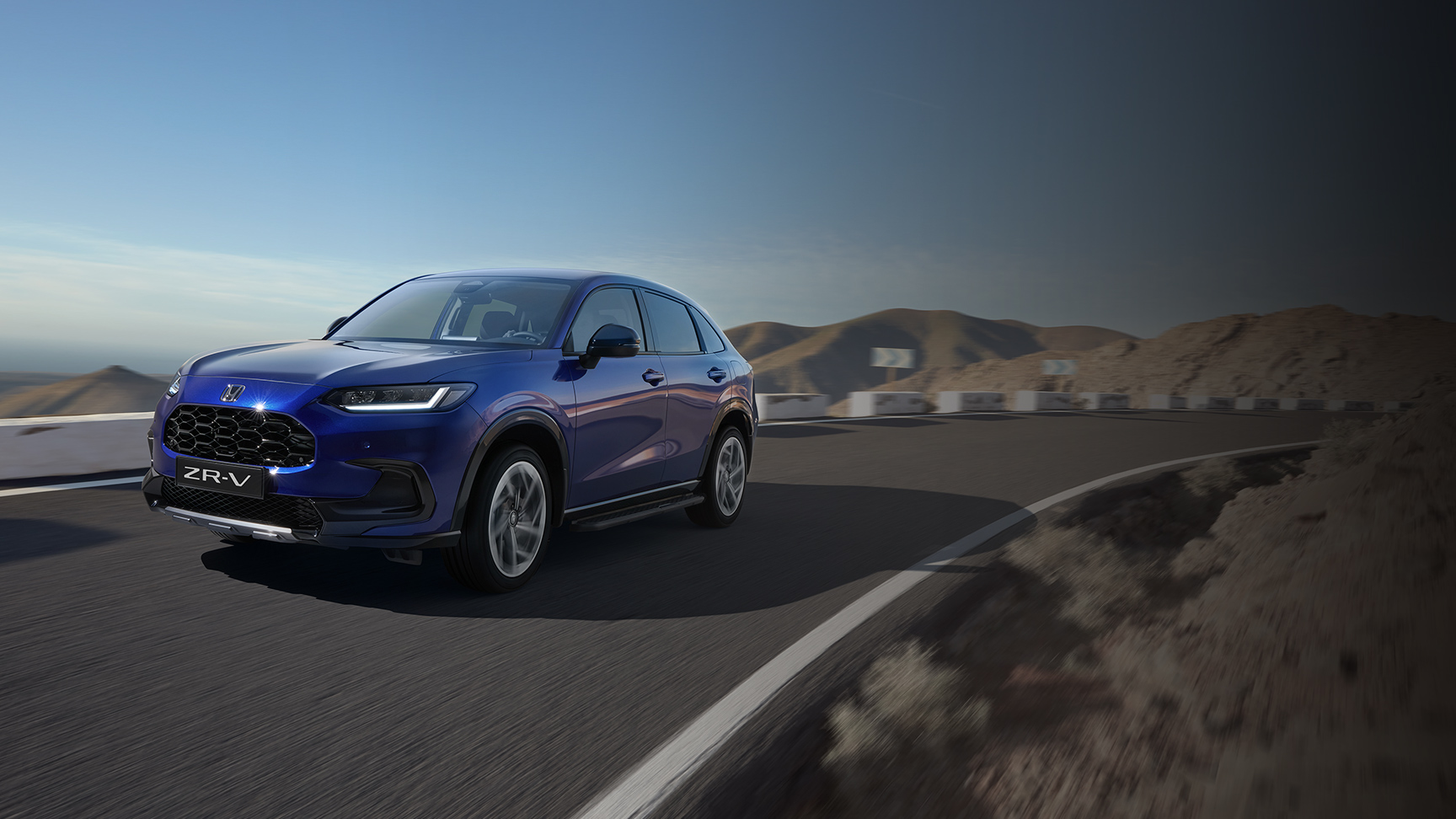 Vue de trois quarts avant du Honda ZR-V avec pack Robust en zone montagneuse.